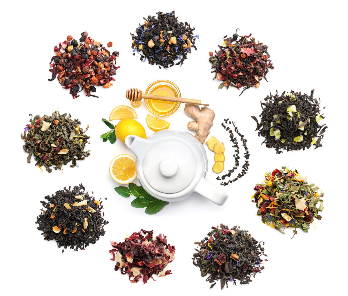 Small piles of different loose leaf teas arranged around a white teapot